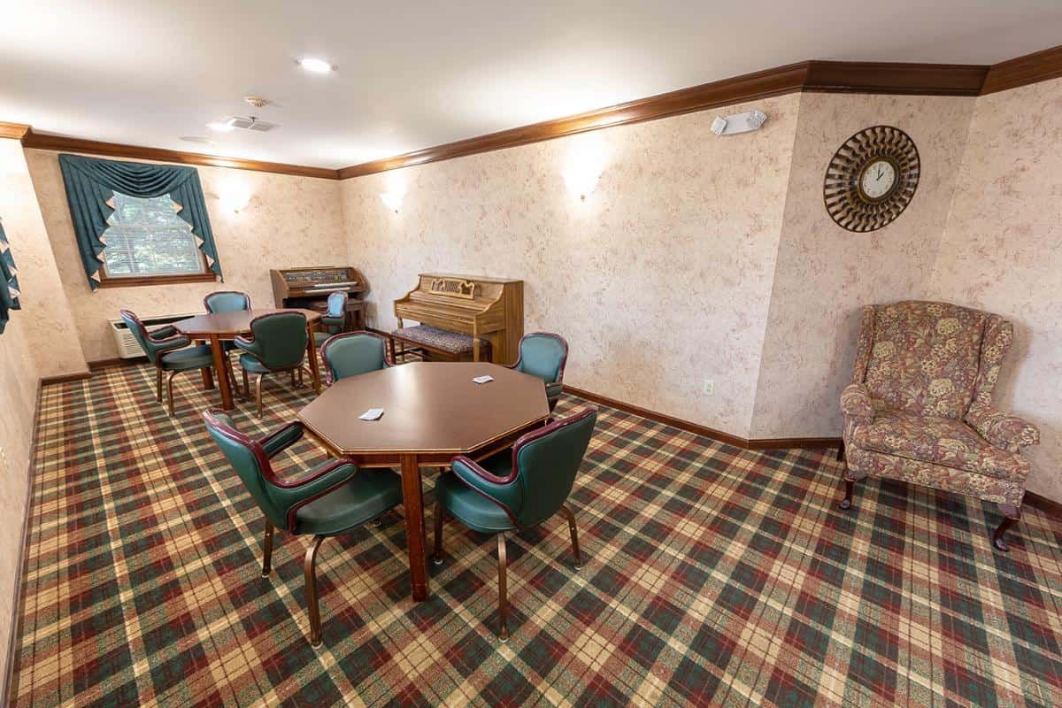 A retro-style room featuring tables and chairs with a patterned carpet.