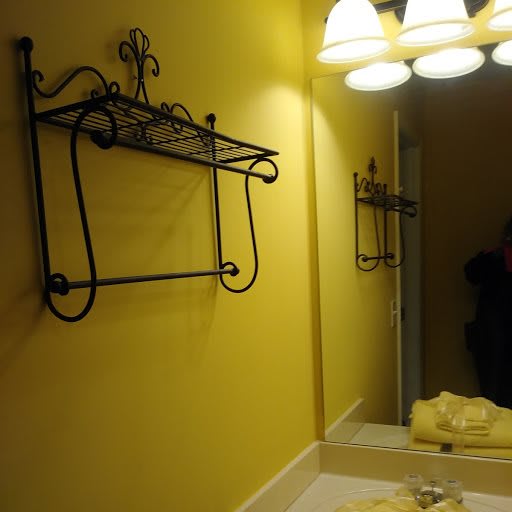 A bathroom with a towel rack and mirror under warm lighting.