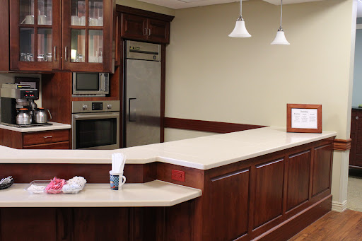 A modern kitchen featuring dark wood cabinets, a countertop, and contemporary appliances.
