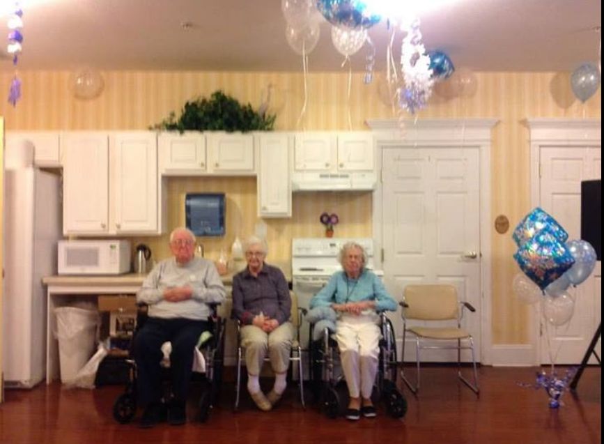 Three seniors sitting in a cozy kitchen-like setting.