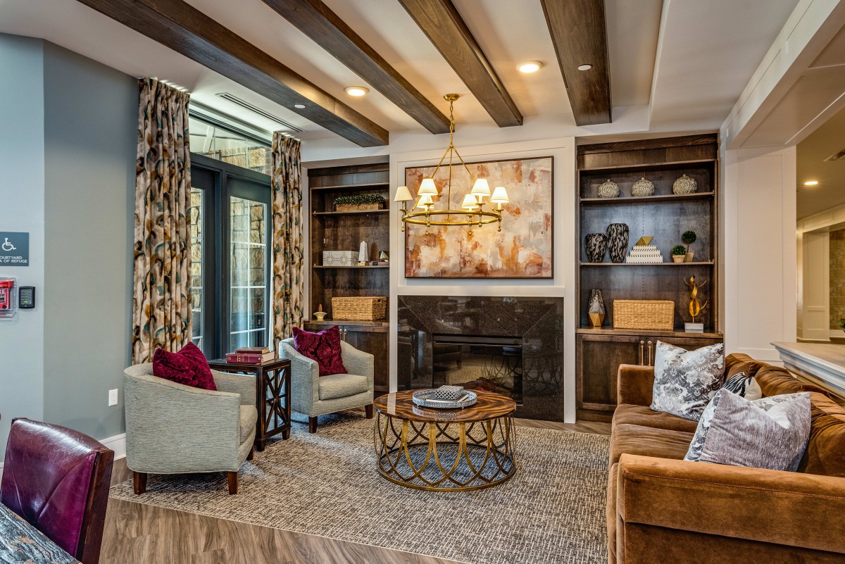 A cozy and elegantly decorated living room featuring a fireplace, comfortable seating, and modern artwork.