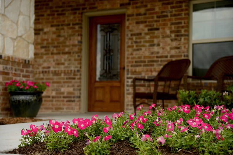 A cozy front porch with blooming flowers and a welcoming entrance.