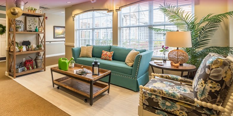 A cozy living room with a teal sofa and wooden coffee table, elegantly arranged with decorative items.