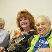 A group of people sitting together and smiling indoors.