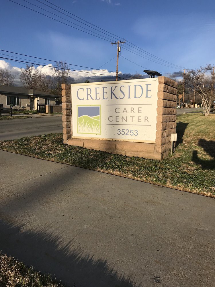 A sign for Creekside Care Center on a sunny day.