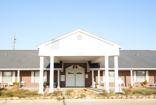 A view of a well-maintained building featuring a prominent front entrance with columns.