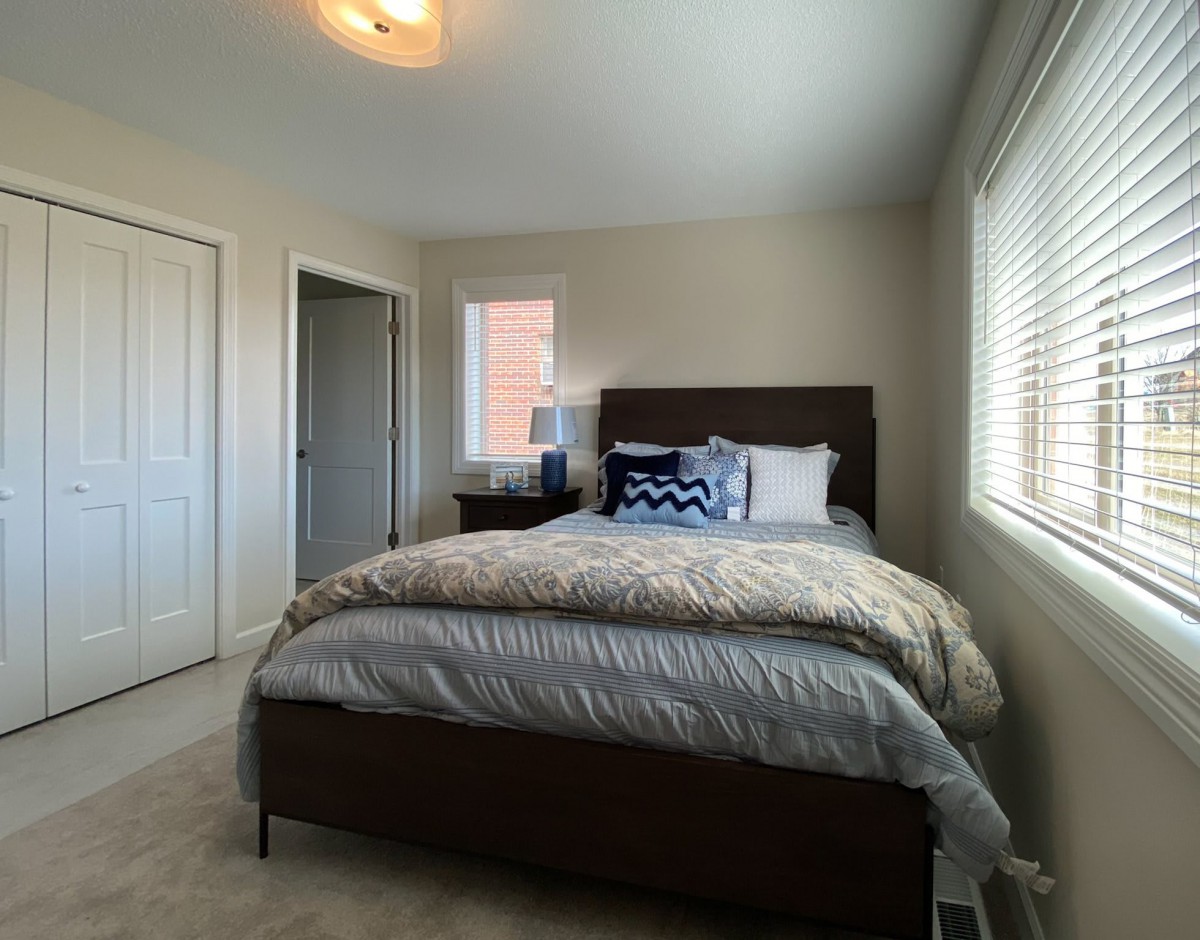 A cozy bedroom with a neatly made bed and decorative pillows.