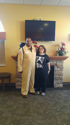 Two individuals pose together, one dressed in a Ghostbusters costume.