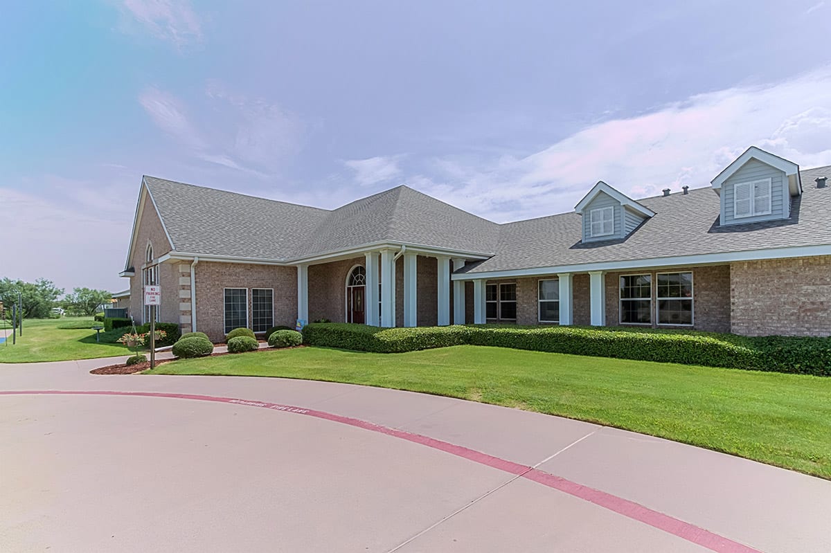 A suburban-style building with a driveway and well-maintained lawn.