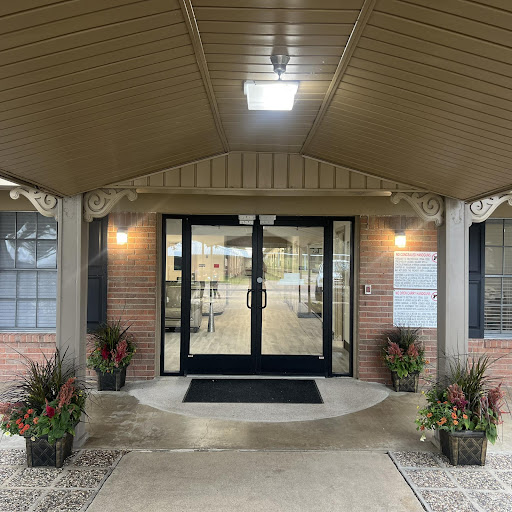 The inviting entrance of a building, featuring warm lighting and flower arrangements.