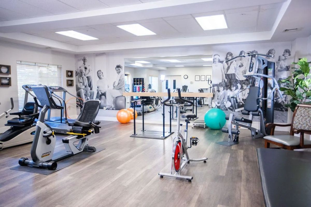 A spacious gym with various exercise equipment, including machines and fitness balls.