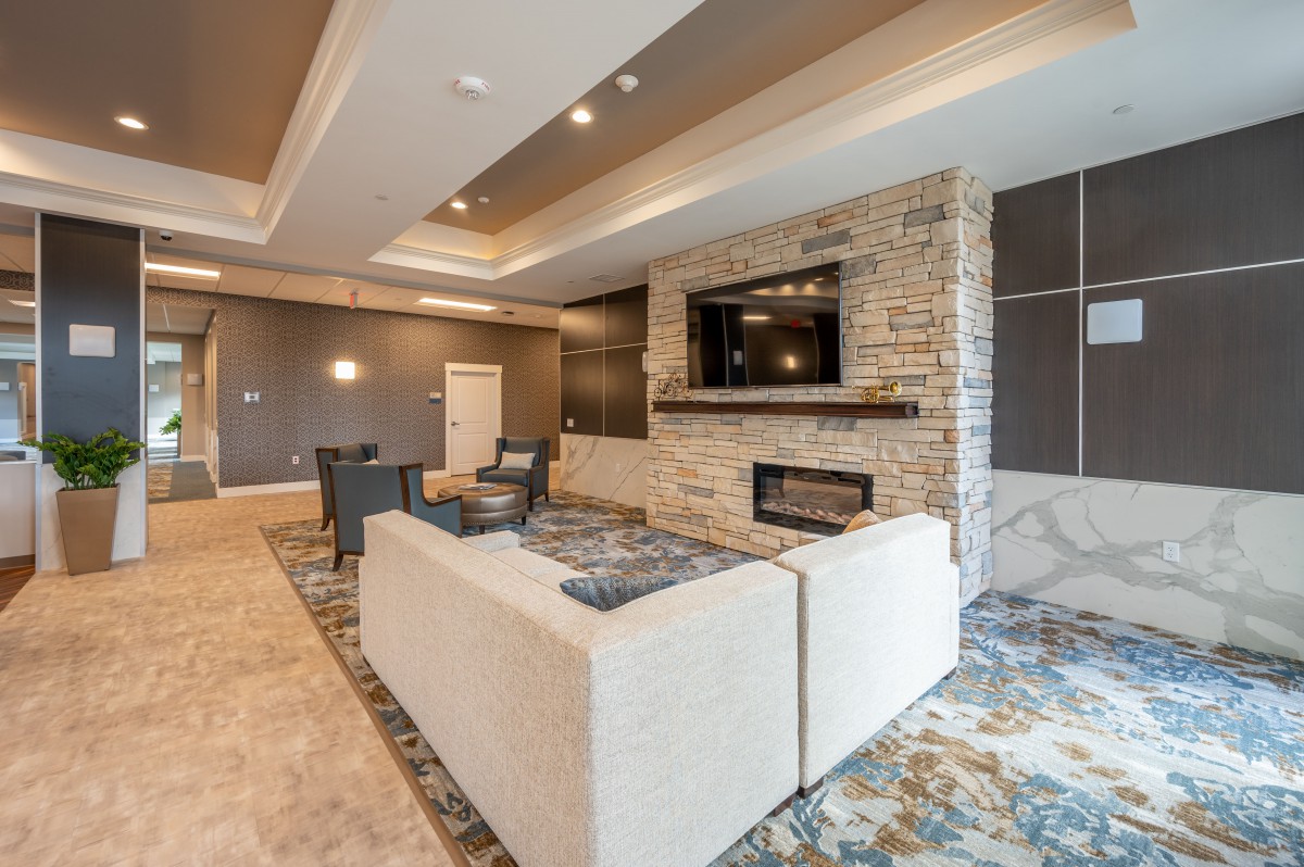 A modern living room featuring a cozy seating area with a sofa, a fireplace, and a mounted television.