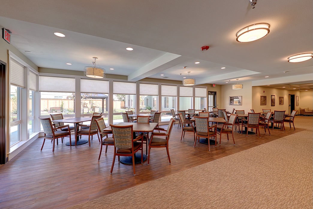 A spacious and well-lit dining area with several tables and chairs.