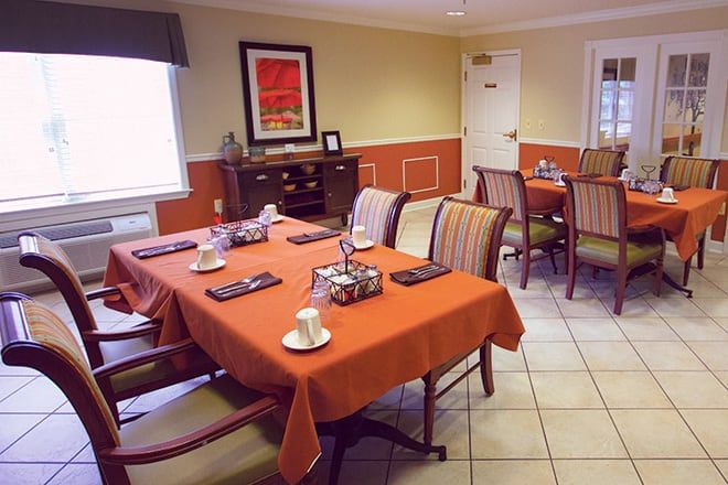 A cozy dining room with tables and chairs set for a meal.
