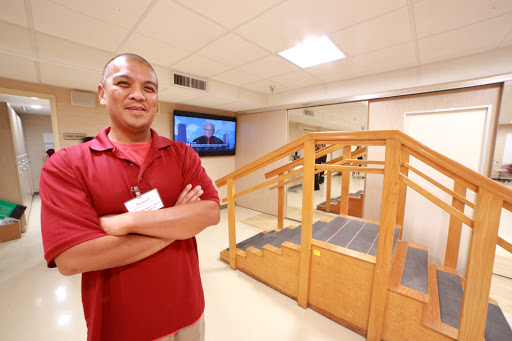 A healthcare professional stands confidently in a rehabilitation facility, highlighting the supportive environment for physical therapy.