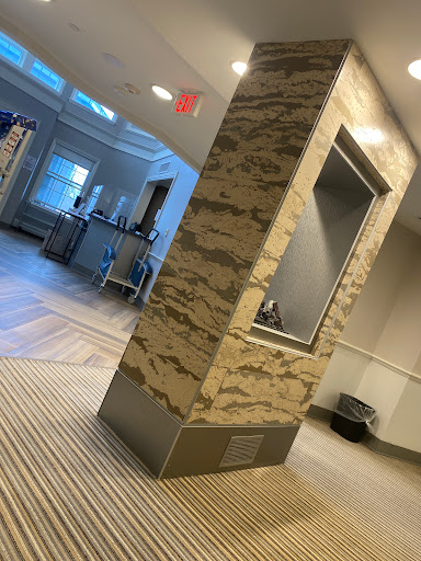 A modern lobby featuring a stylish marble column and contemporary furnishings.