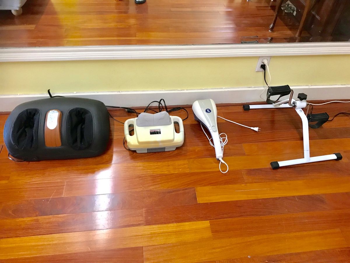 A collection of exercise and massage equipment arranged on a wooden floor.
