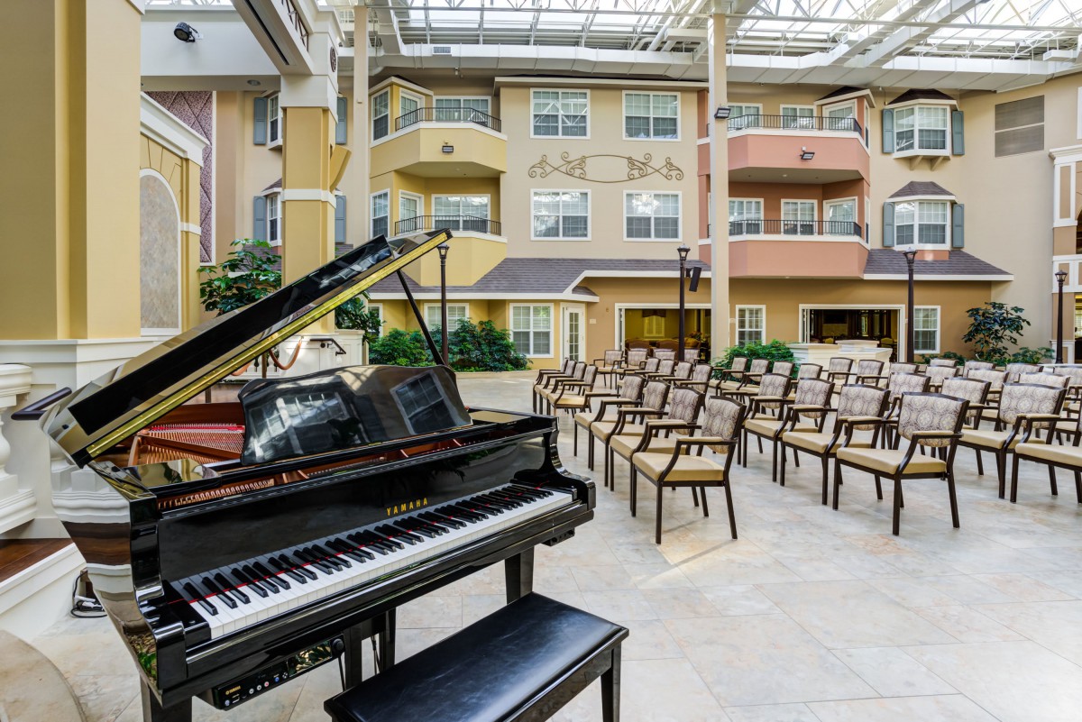 A grand piano in a spacious indoor area with arranged seating.