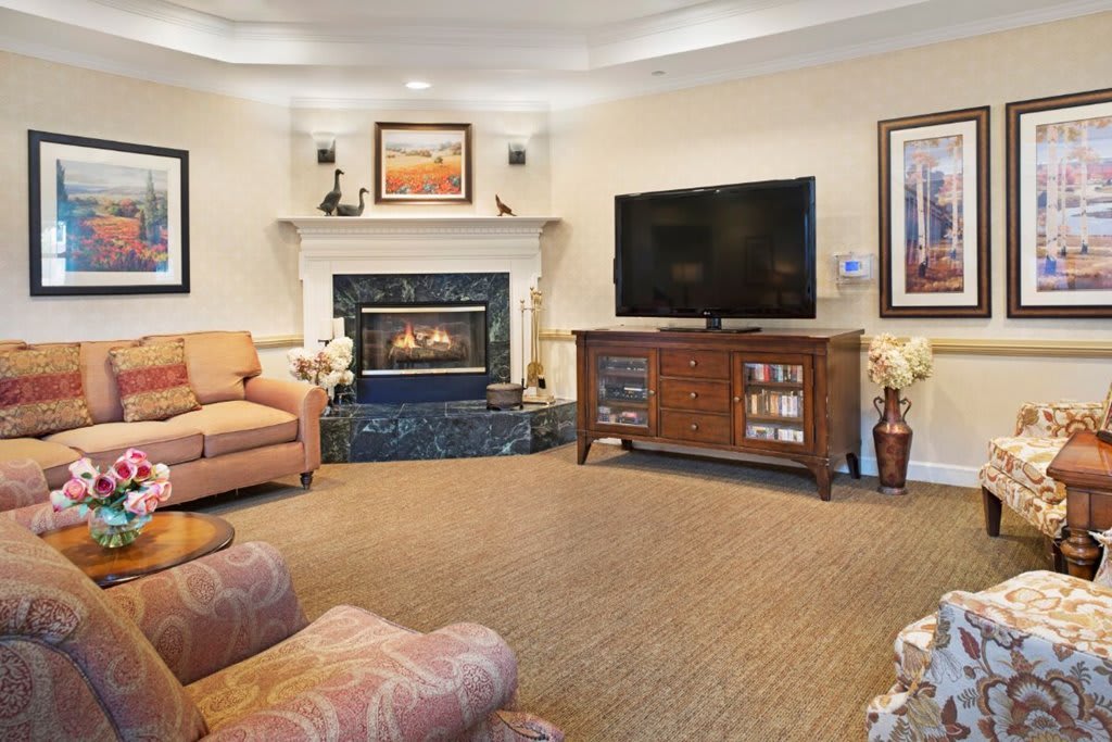 A cozy living room with a fireplace, television, and comfortable seating.