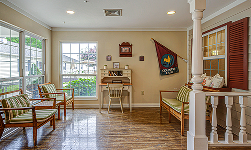 A cozy waiting room with a desk and chairs, decorated with a flag and other decor items.