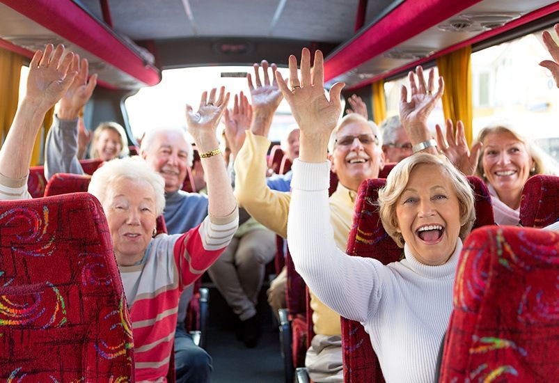 A group of happy seniors enjoying a bus trip together.