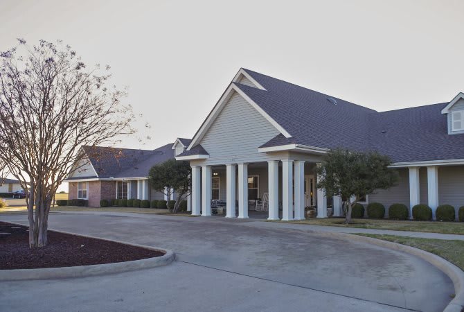 A view of a healthcare clinic with a prominent entrance and surrounding parking area.