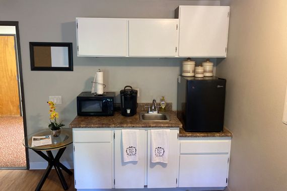 Compact kitchenette setup with appliances and storage cabinets.