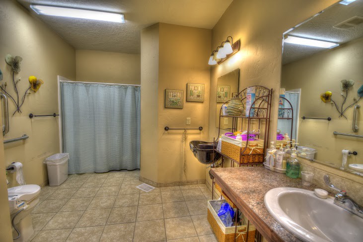 A modern bathroom with a shower curtain, sink area, and decorative elements.