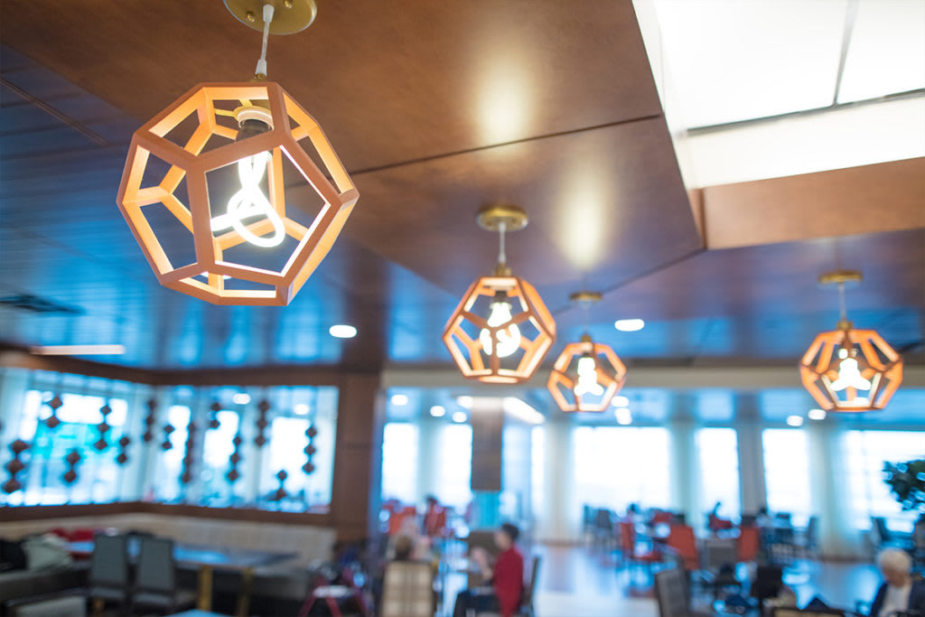 A modern restaurant interior featuring geometric ceiling light fixtures.