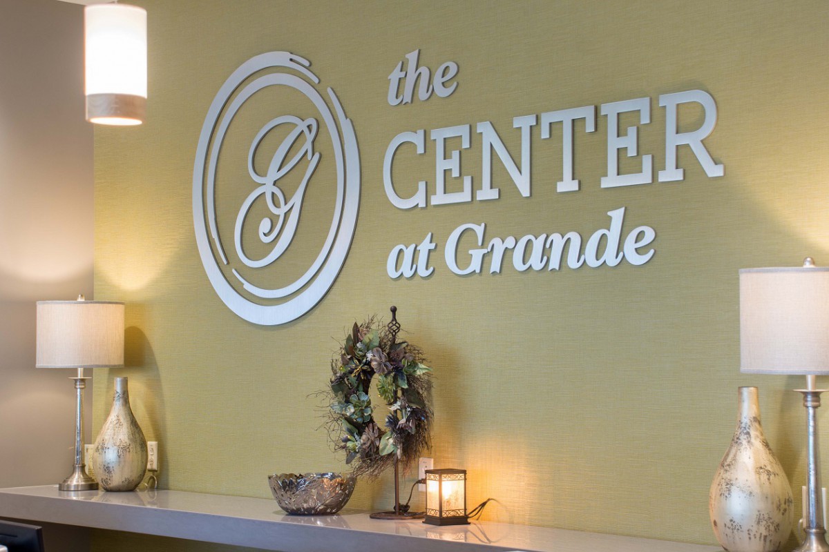 The interior of a venue featuring the sign 'the Center at Grande' with decorative elements.