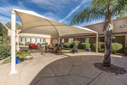 A tranquil outdoor patio with shaded seating, perfect for relaxation under the sun.