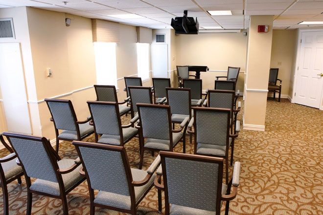 A small conference room set up with chairs facing a podium and projector.