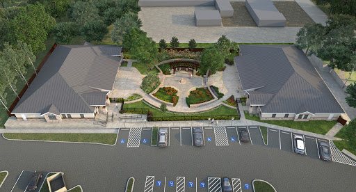 Aerial view of a landscaped area with buildings and a parking lot.