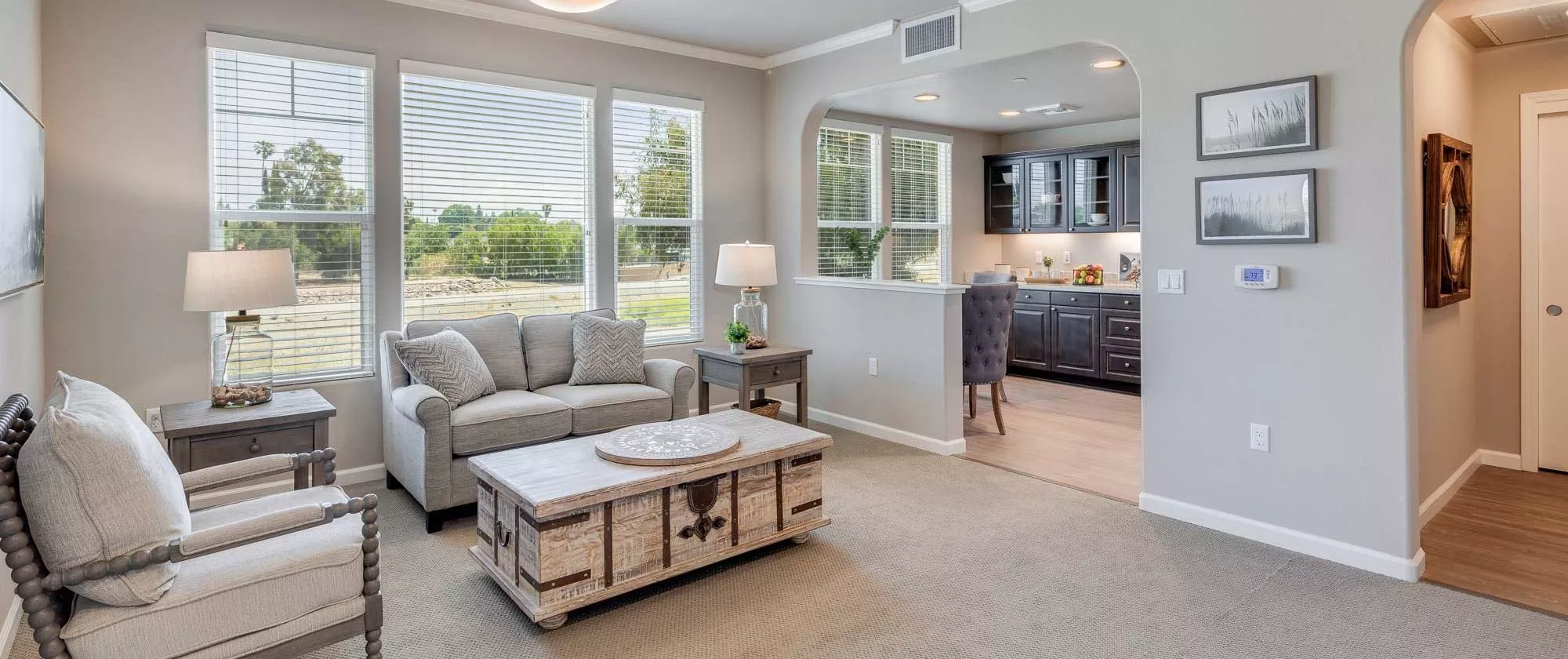 A cozy living room with a sofa, coffee table, and a view into the kitchen area.