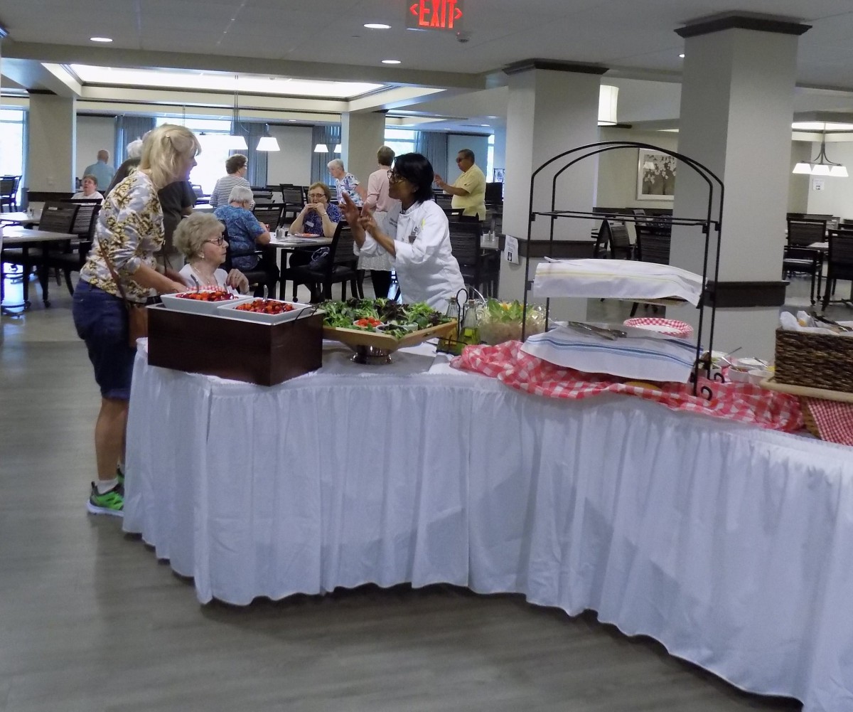 People gathering around a buffet table in an indoor setting.