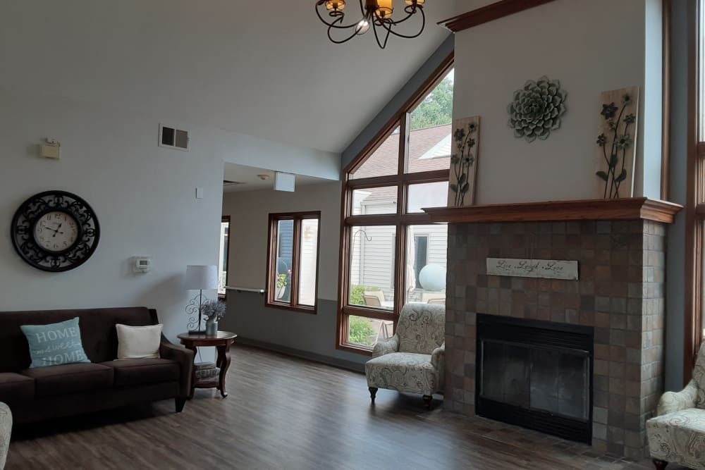 A cozy living room with a fireplace, large windows, and comfortable seating.