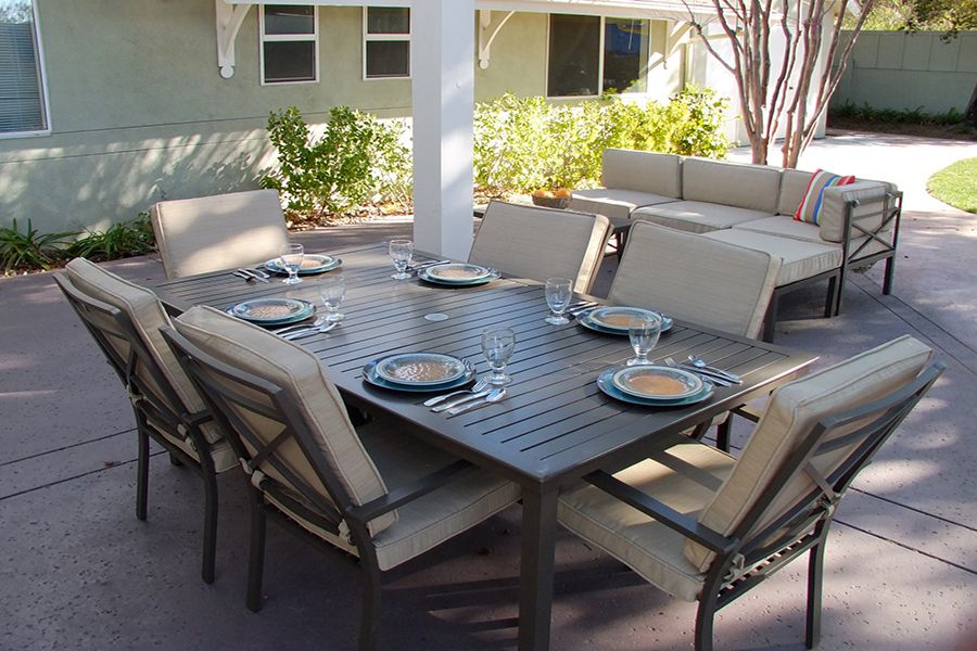 An outdoor patio dining set with a table and chairs arranged for a meal.