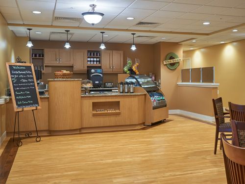An empty cafe interior with a wooden counter and display case.