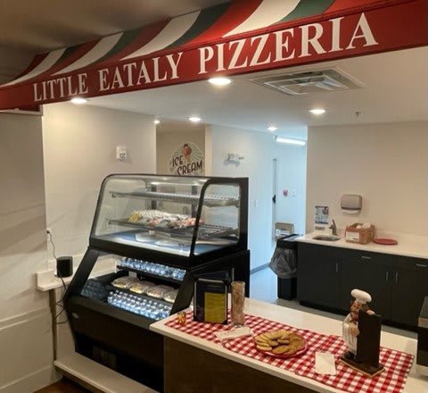Interior of Little Eataly Pizzeria with a food display counter and Italian-themed decor.