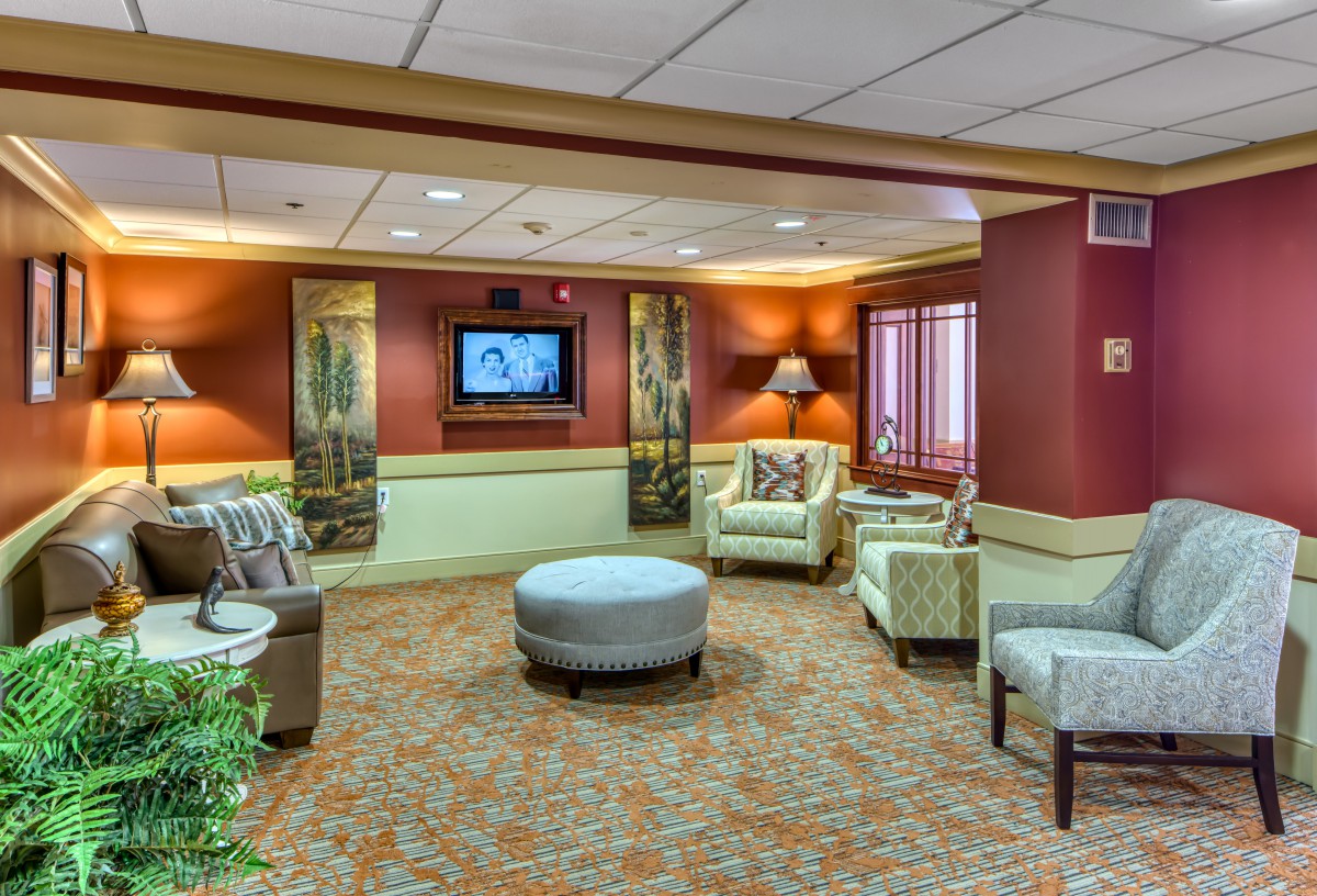 A warmly decorated lobby with comfortable seating and a television.