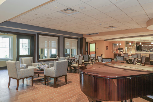 A cozy lounge area featuring elegant seating and a grand piano, perfect for relaxation and social gatherings.