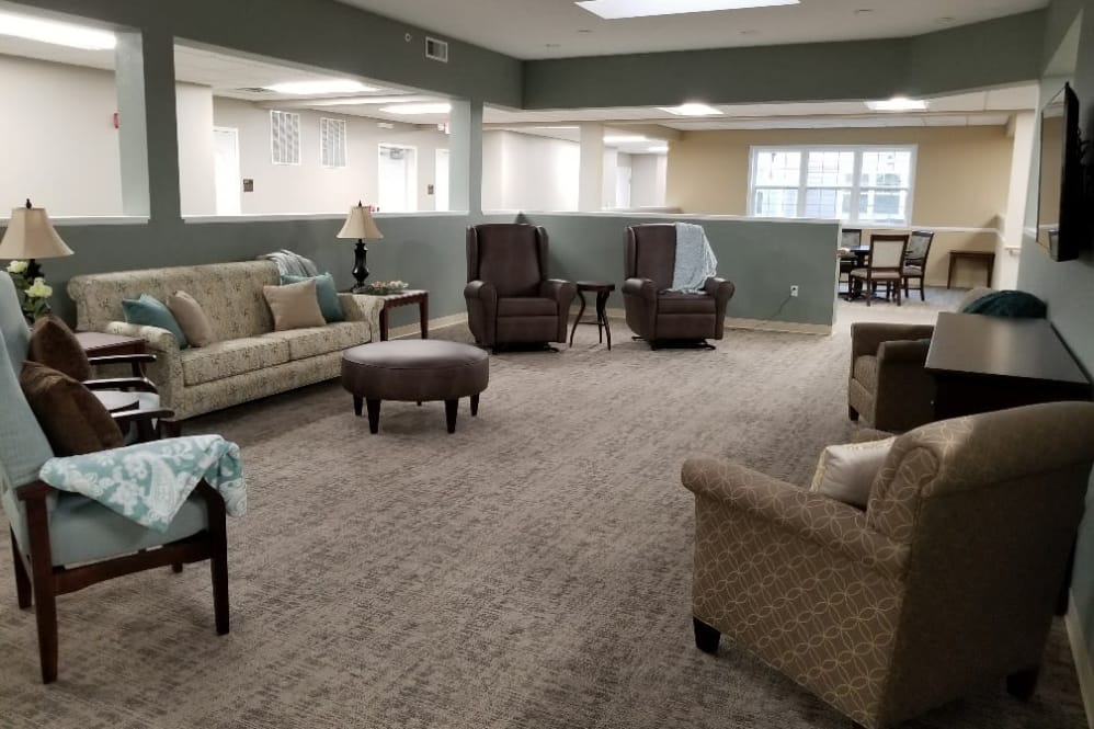A cozy living room with comfortable seating and a carpeted floor.