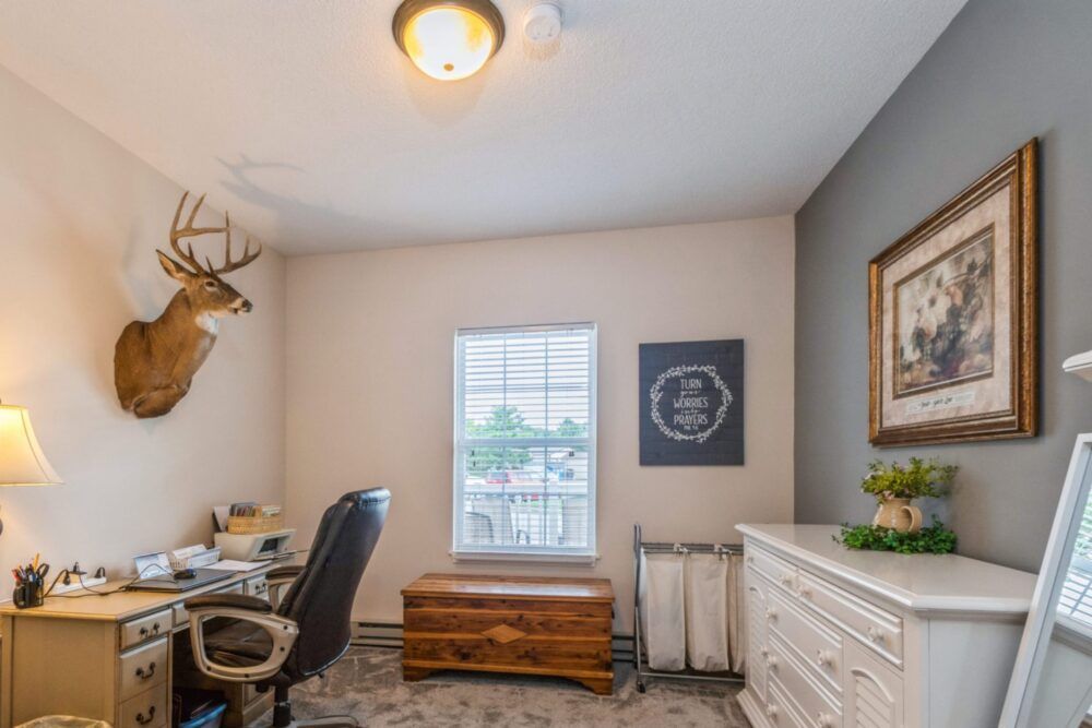 A cozy home office with a desk, chair, and decorative elements.