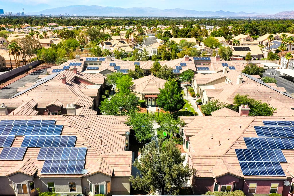 Aerial view of a suburban neighborhood with solar panels on rooftops, showcasing renewable energy adoption.