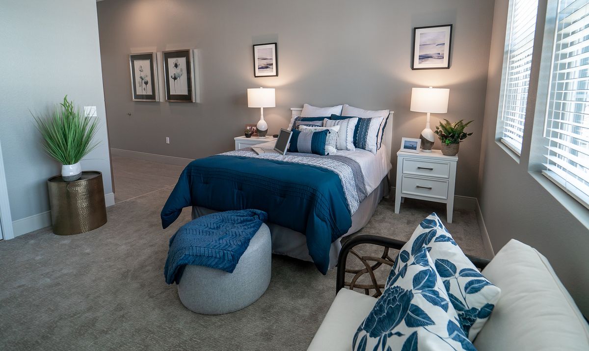 A modern bedroom with blue accents and elegant decor.