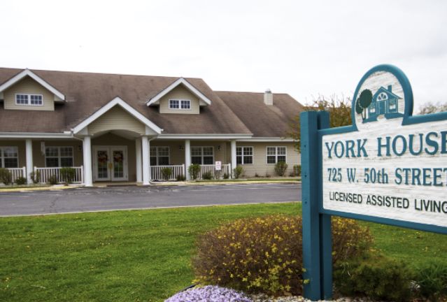 Exterior view of a healthcare facility with a visible sign in the foreground.