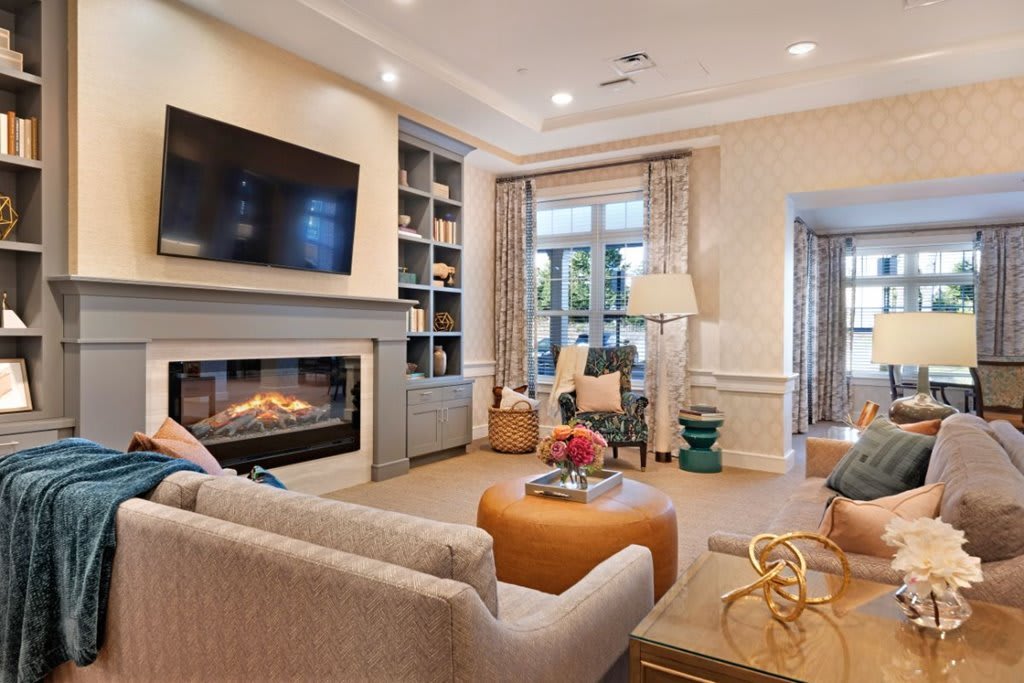A cozy and modern living room featuring a fireplace, television, and comfortable seating.