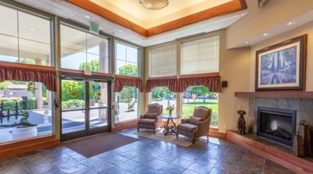A welcoming lobby area with chairs by large windows allowing natural light.