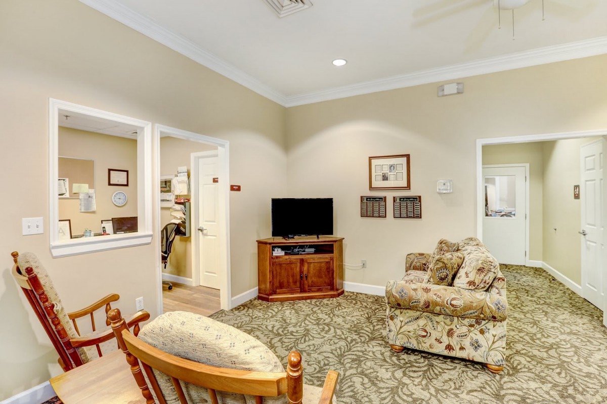 A cozy living room featuring a television, sofa, and warm decor.