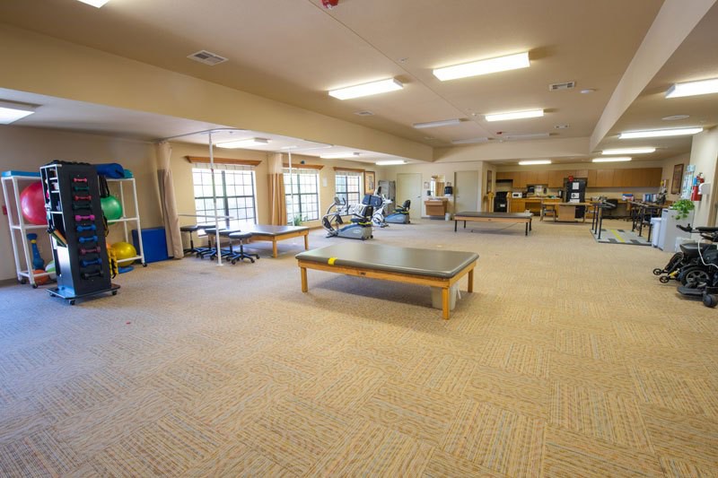 A spacious fitness center with various gym equipment and exercise areas.